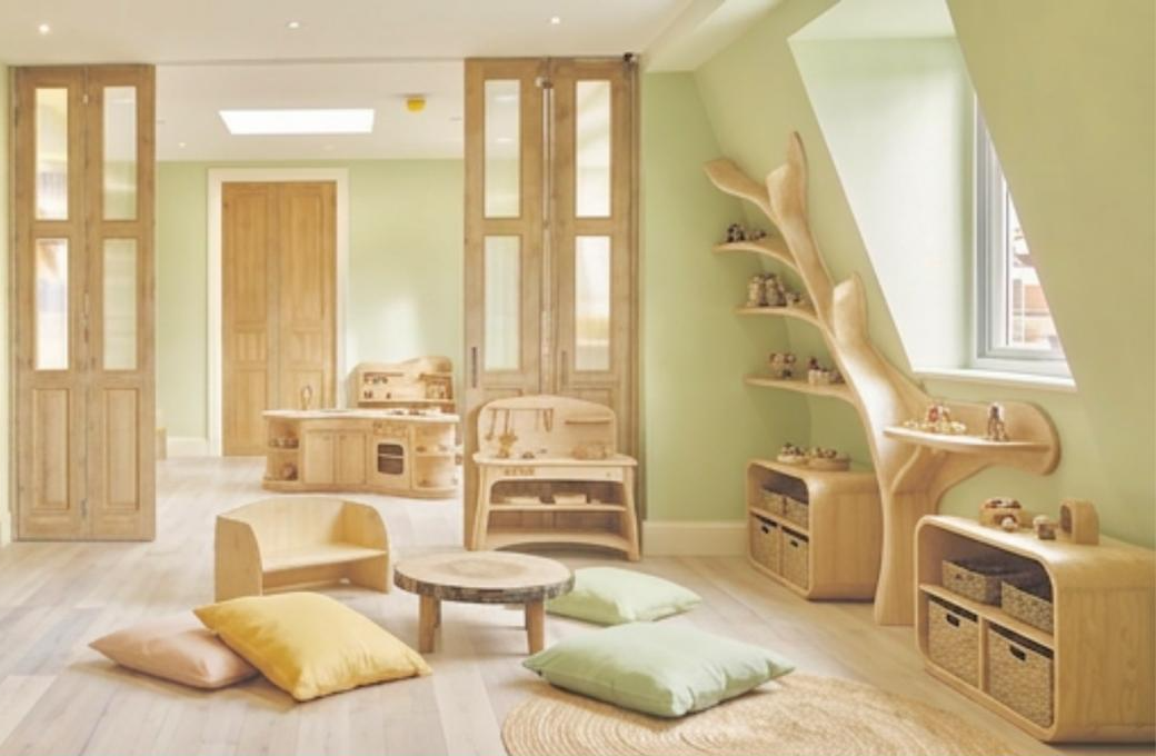A light, nature-inspired nursery room with wooden furniture and soft cushions